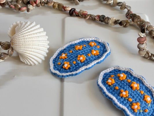 Handmade blue crochet hair clips with yellow floral embroidery and white scalloped border – Bluebell Bloomies accessory for girls
